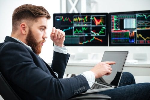 man sitting and trading in the laptop