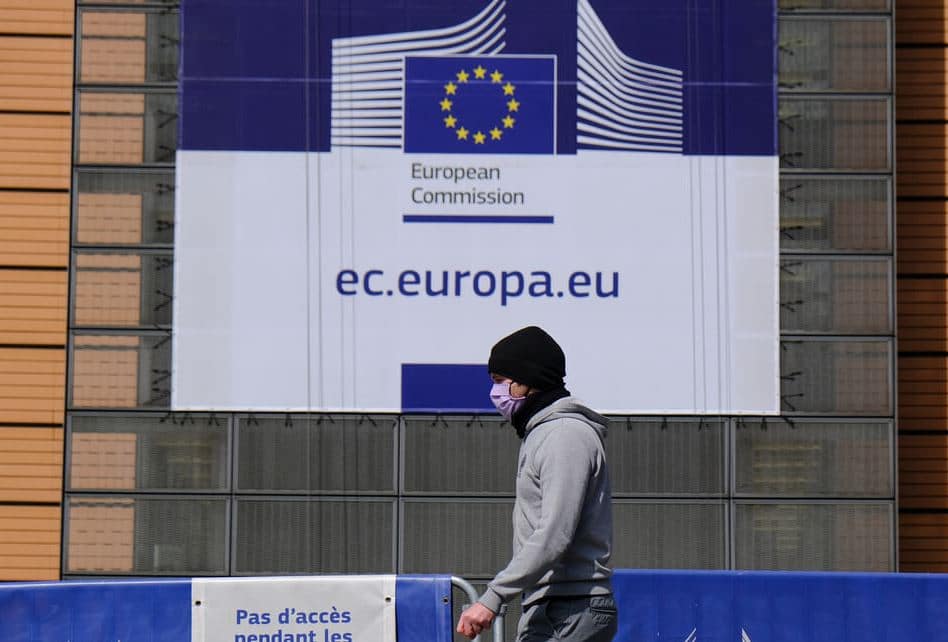 EUR A pedestrian wearing a protective face mask walk in front of the European Commission headquarters in Brussels Belgium