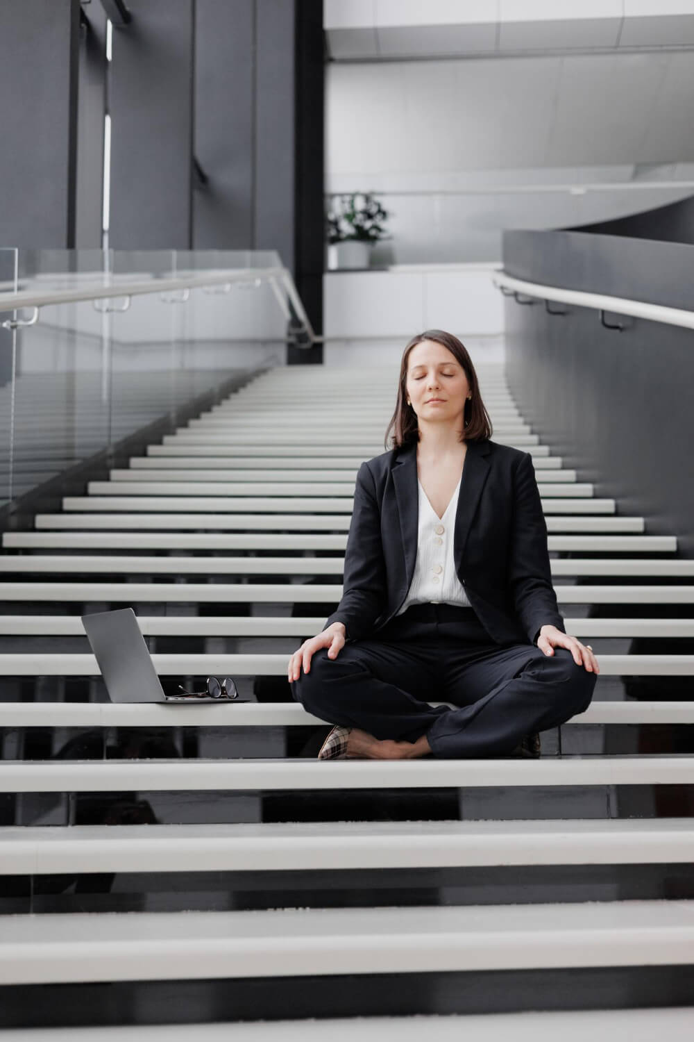 business woman with laptop office business center sits steps lotus position meditates relax (1)
