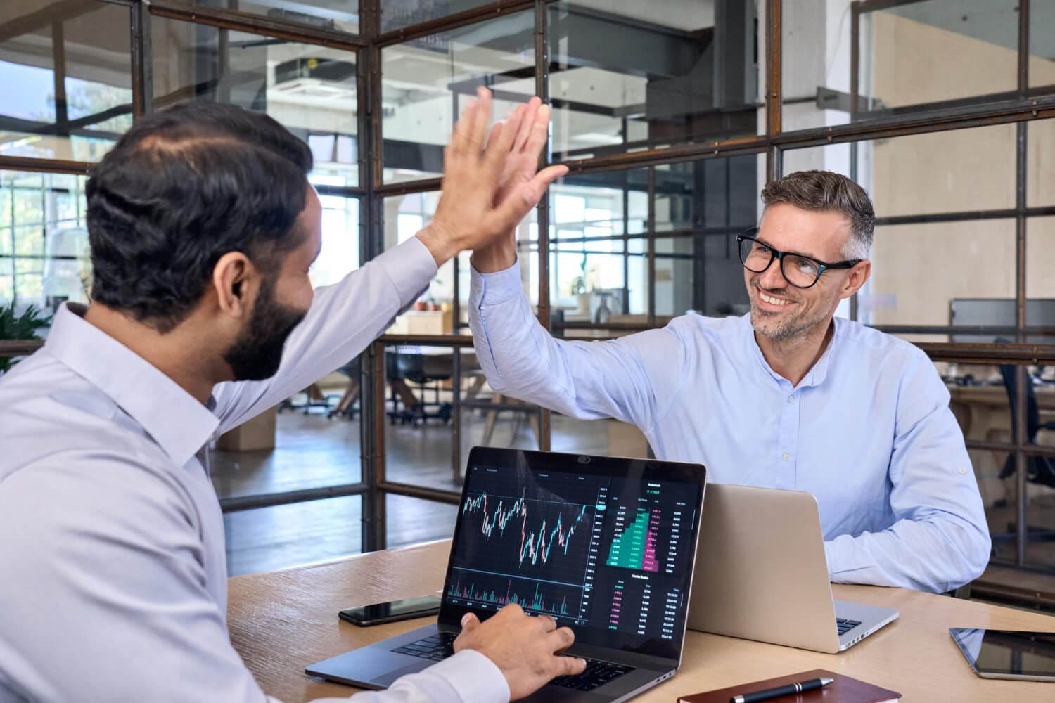 two happy successful diverse traders investors giving high five (1)