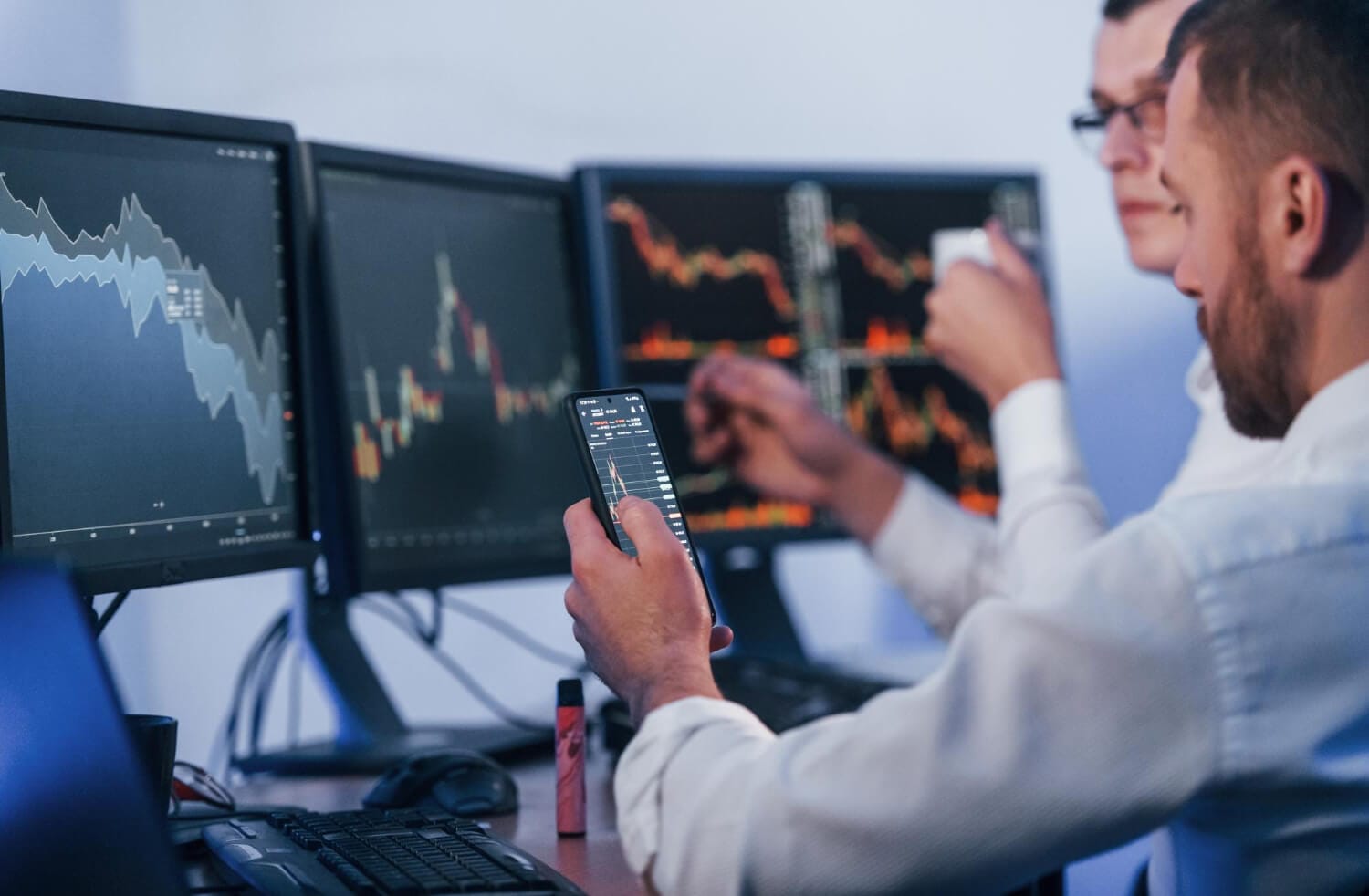 busy day two stock traders working office with exchange technology (1)