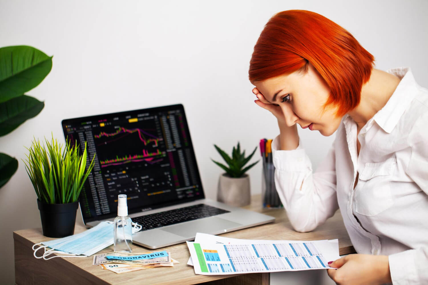 sad woman is looking falling stock charts during epidemic covid 19 (1)
