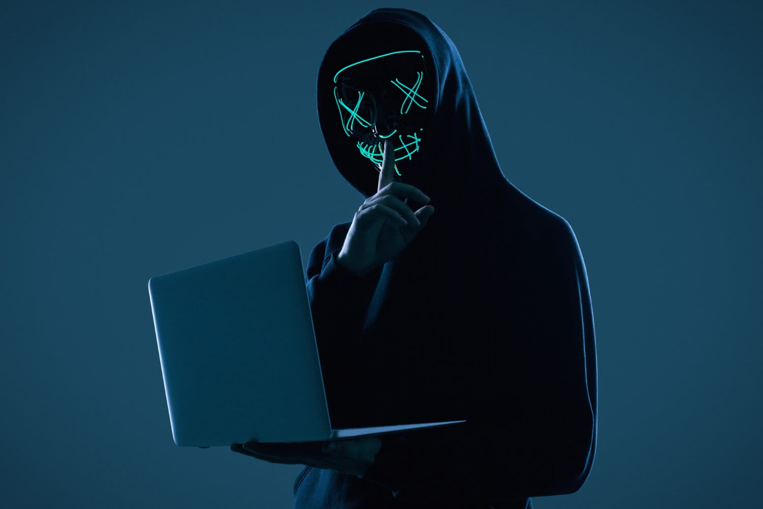 anonymous man black hoodie neon mask hacking into computer (1)